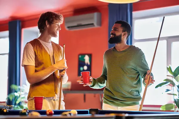 stock image Friends laugh and chat during a casual game of billiards.