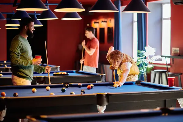 stock image Friends play a game of billiards in a well-lit bar.