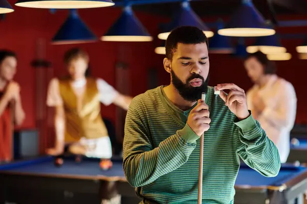 stock image A man prepares to take a shot in a game of billiards.