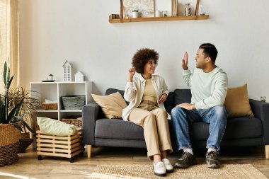 Afro-Amerikalı bir çift evlerinde bir kanepede oturup işaret diliyle iletişim kuruyor..