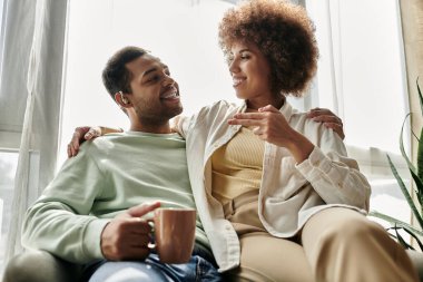 An African American couple shares a loving conversation using sign language at home. clipart