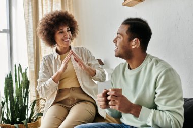 Mutlu bir Afro-Amerikalı çift evde işaret diliyle iletişim kuruyor..