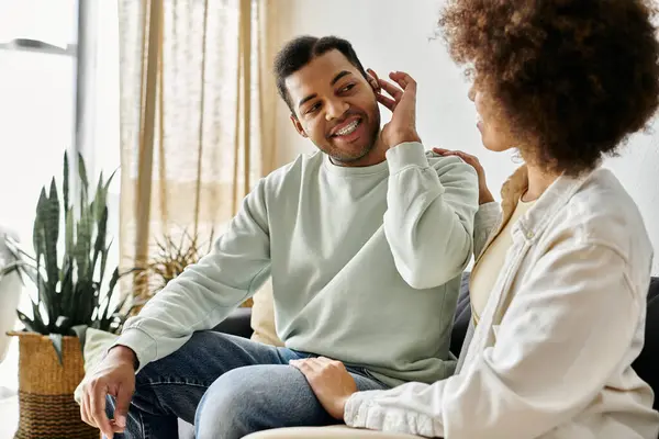 stock image An African American couple, sign language, sitting on a couch in their living room.