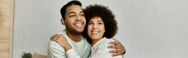 An African American couple uses sign language to communicate while sitting at home.