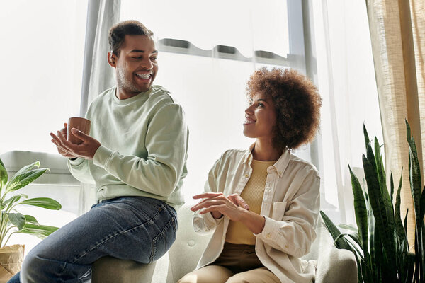 An African American couple communicates through sign language while relaxing at home.
