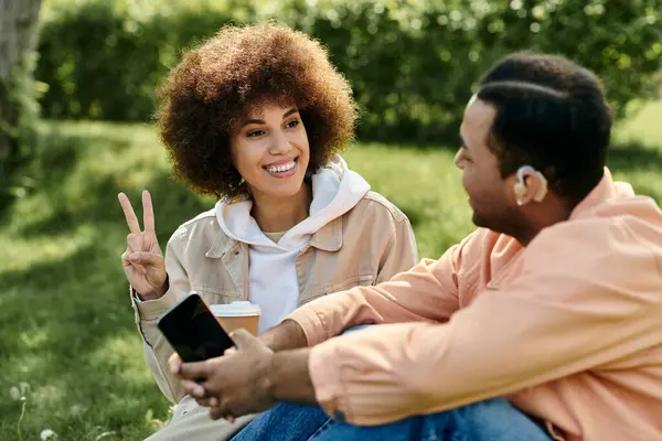 stock image A couple signs to each other while sitting in a park on a sunny day.