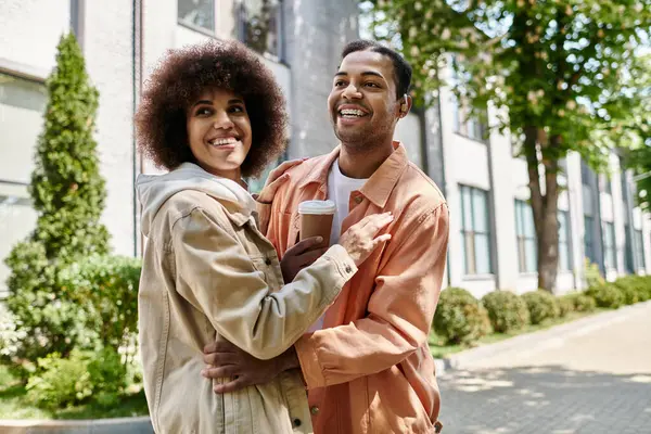 stock image A happy African American couple embraces while walking through a city, using sign language to communicate.