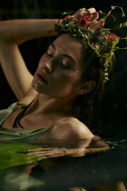 A woman with a floral crown poses in a swamp, surrounded by greenery and water. clipart