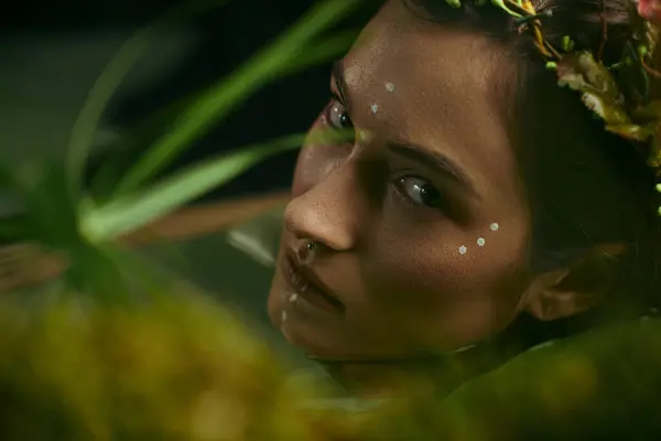 stock image A woman with a floral crown poses in a swampy, green environment.