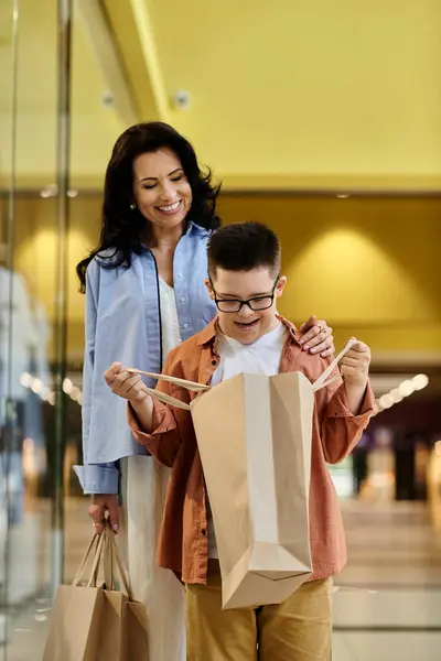 stock image A mother and her son with Down syndrome are walking through a shopping mall, enjoying a day of shopping and bonding.