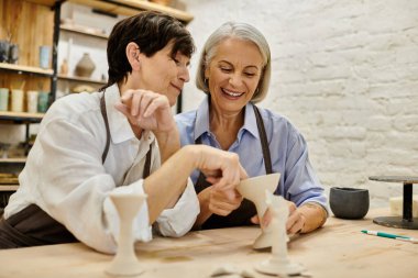 İki olgun kadın, lezbiyen bir çift, samimi bir stüdyoda çömlek seansının keyfini çıkarıyorlar..