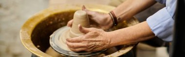 A womans hands shape clay on a pottery wheel. clipart