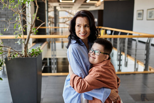 A mother and son with Down syndrome share a loving embrace in a shopping mall.