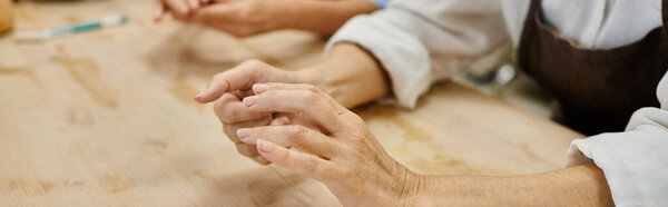 A close-up of a mature lesbian couple crafting pottery in a cozy studio.