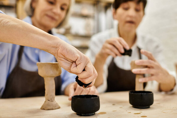 Две женщины занимаются гончарным делом вместе в уютной студии.