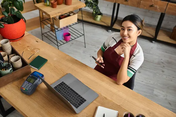 Gülümseyen Asyalı bir kadın, bir fabrika sahibi, telefonunu kontrol etmek ve büyüyen işini düşünmek için meşgul olduğu güne ara veriyor..