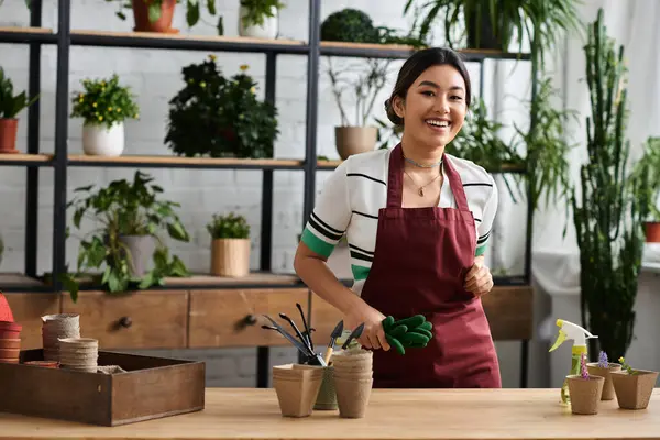 Asyalı bir kadın fabrikadaki tezgahta çalışırken gülümsüyor..