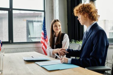 Teens at Model UN, shaking hands and discussing diplomatically. clipart