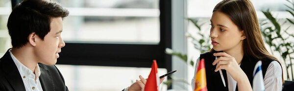 Two teenagers engage in a serious discussion during a Model United Nations simulation.