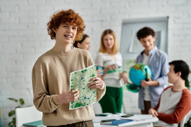 BM Model Konferansı 'na katılan genç çocuğun elinde bir harita var..