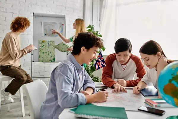 Gençler BM Model oturumu sırasında bir masanın etrafında toplanıp harita üzerinde çalışıyorlar..