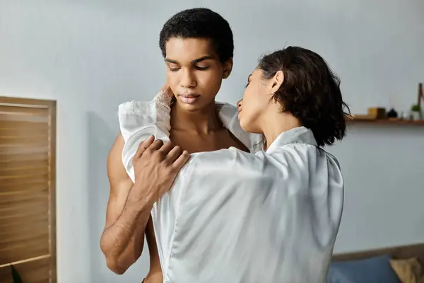 stock image An Asian woman and an African American man hug and kiss intimately