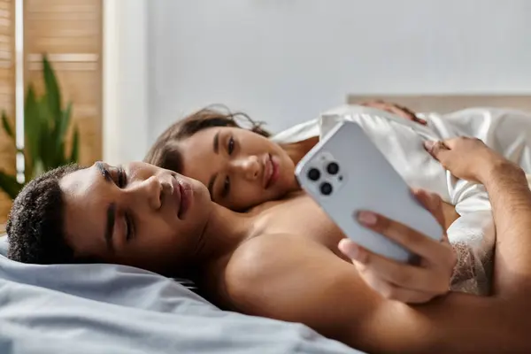 stock image A young couple enjoys a relaxing moment together in their bedroom.