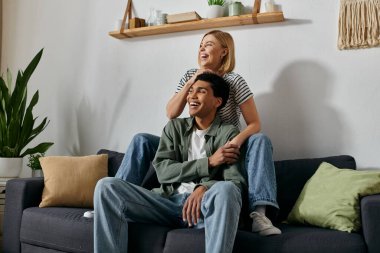 Irklar arası genç bir çift modern dairelerinde rahatlar ve birbirlerine eşlik etmekten zevk alır..