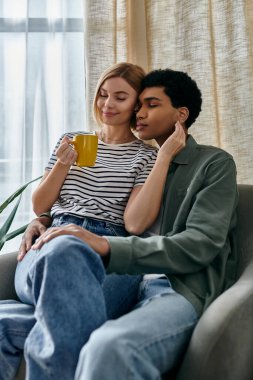 Irklar arası genç bir çift modern dairelerinde rahatlıyor ve sıcak bir öğleden sonranın tadını çıkarıyor..