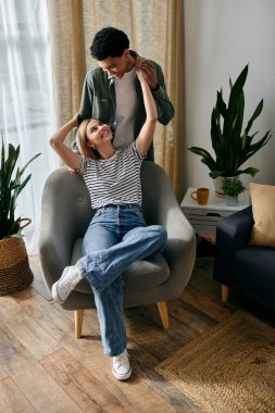 Genç, çok kültürlü bir çift modern apartmanlarında rahatlatıcı bir öğleden sonra geçiriyor..