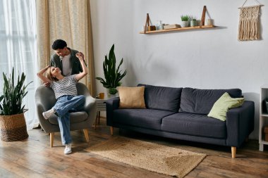 Genç, çok kültürlü bir çift modern apartmanlarında rahat bir öğleden sonranın tadını çıkarıyor..