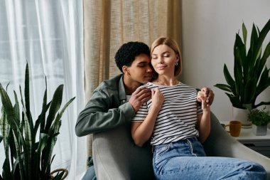 A young multicultural couple enjoys a cozy moment together in their modern apartment. clipart