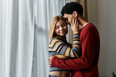 Mutlu bir ırklar arası çift, modern dairelerinde, çeşitli ilişkilerin güzelliğini sergileyerek birlikte hassas bir anın tadını çıkarır..