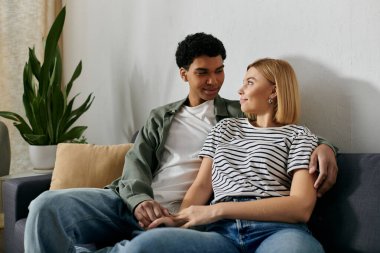 Genç, çok kültürlü bir çift modern dairelerinde rahatlar ve birlikte vakit geçirmekten zevk alır..