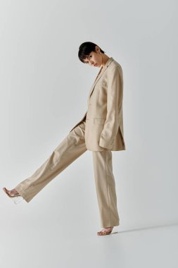 A woman in a beige suit poses against a white backdrop. clipart