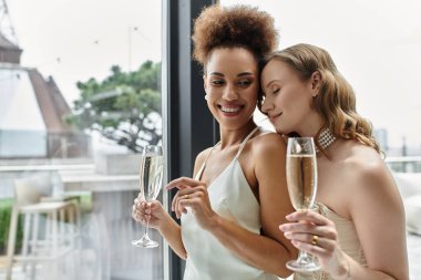 A loving lesbian couple celebrates their wedding with champagne. clipart