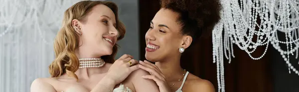 stock image Two women in wedding attire share a loving moment.