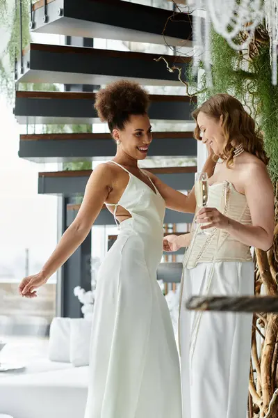stock image Two brides in white dresses share a laugh during their wedding reception.