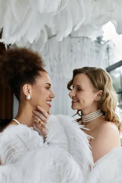 stock image Two brides, dressed in white, share a tender moment on their wedding day.