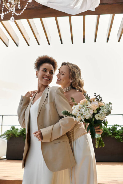 Two brides in love embrace on their wedding day.