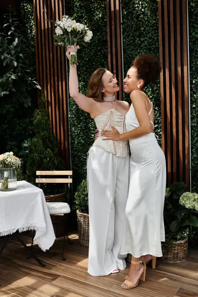 stock image Two brides in white embrace as they celebrate their wedding day.