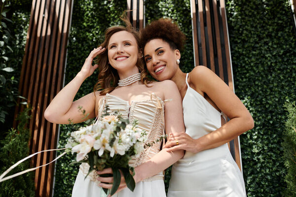 Две невесты в белых платьях счастливо обнимаются на свадебной церемонии..