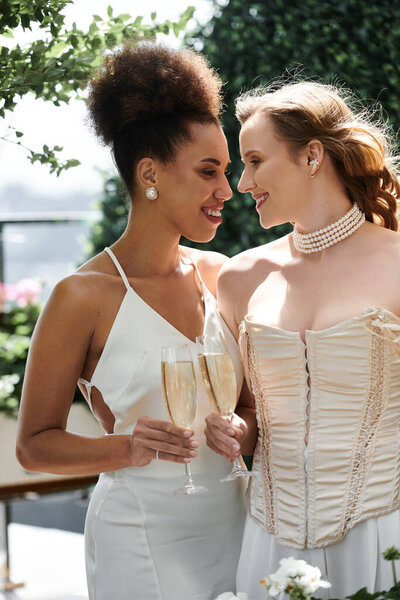 Любящая пара лесбиянок тосты за их брак с бокалами шампанского.