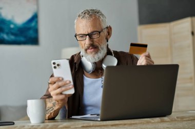 Dövmeleri ve gri saçı olan olgun bir eşcinsel evden uzakta çalışıyor. Telefonunu, laptopunu ve kredi kartını kullanıyor..