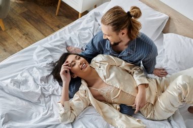 Sevgi dolu bir çift yatakta birlikte vakit geçirir, güler ve günlerinin tadını çıkarırlar..