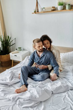 A loving couple relaxes on their bed in their home, enjoying a peaceful moment together. clipart