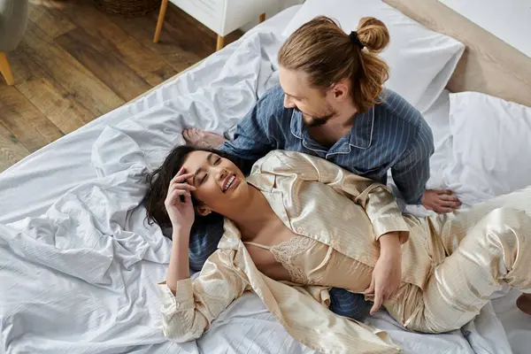 Sevgi dolu bir çift yatakta birlikte vakit geçirir, güler ve günlerinin tadını çıkarırlar..