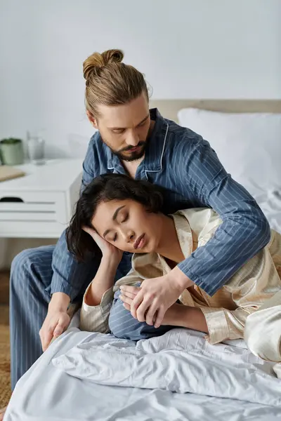 stock image Couple relaxes quietly on bed, woman resting head in partners lap.