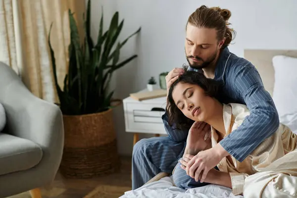 Stock image A loving couple relaxes at home, the man gently stroking his partners hair.