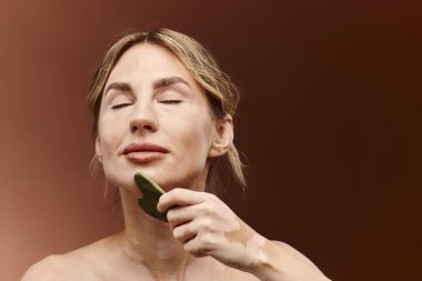 Vitiligo 'su olan genç bir kadın rahatlatıcı bir güzellik için yeşim taşı kullanıyor..